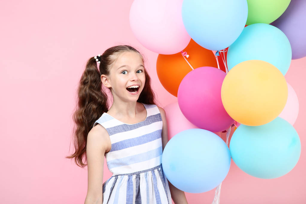 Νεαρό κορίτσι με χρωματιστά μπαλόνια σε ροζ φόντο - Φωτογραφία, εικόνα