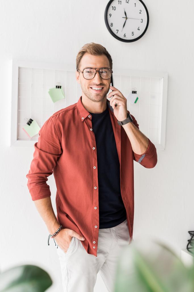 улыбающийся бизнесмен в очках разговаривает на смартфоне
 - Фото, изображение