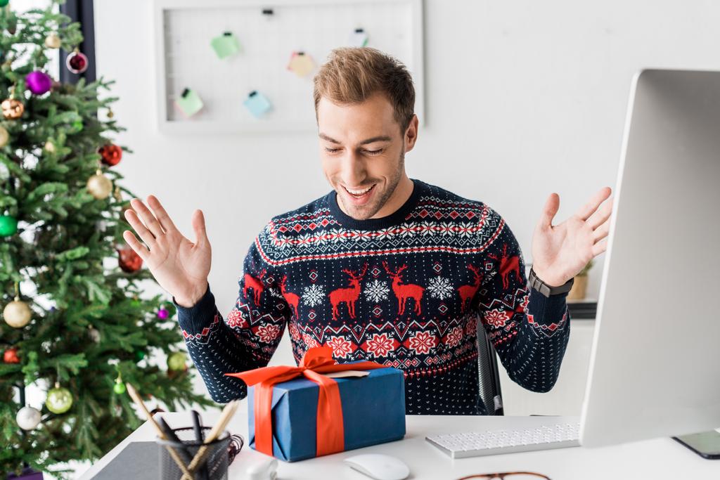homme d'affaires surpris en pull d'hiver regardant boîte cadeau de Noël
 - Photo, image