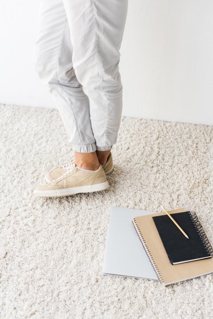 Nízké řez příležitostné člověka a notebooku na béžový koberec - Fotografie, Obrázek
