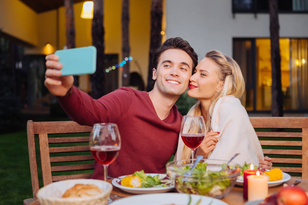freudiger netter Mann, der ein Selfie mit seiner Freundin macht - Foto, Bild