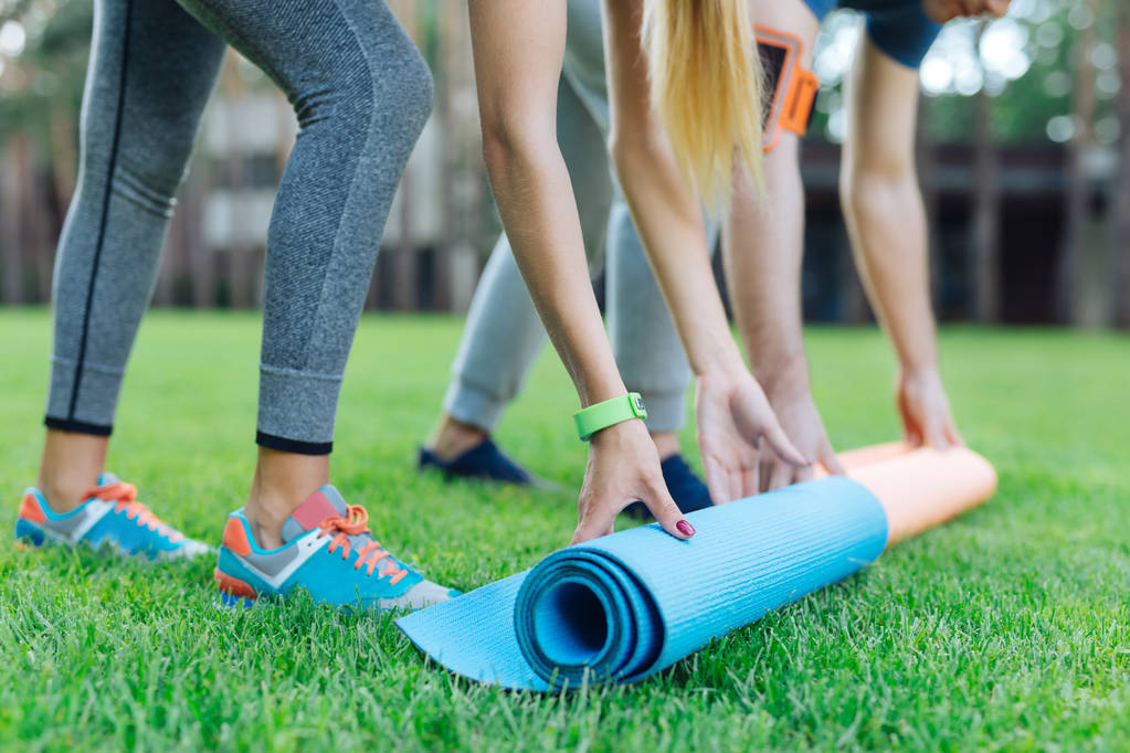 Close up of yoga mats being put on the grass - Photo, Image
