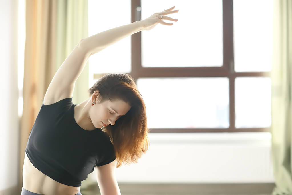 λεπτή γυναίκα κάνει το τέντωμα άσκηση σε γυμναστήριο, γιόγκα ισορροπία - Φωτογραφία, εικόνα