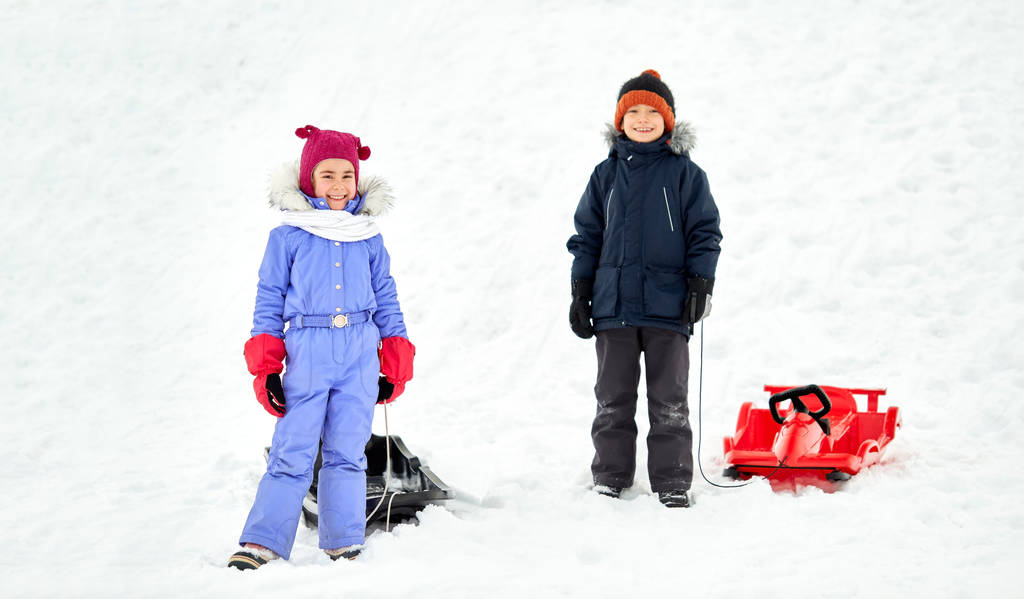 petits enfants heureux avec des traîneaux en hiver
 - Photo, image