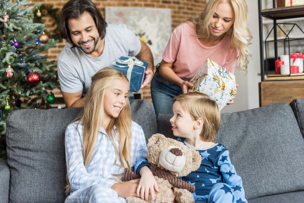 rodiče představí vánoční dárky rozkošný radost dětem v pyžamu  - Fotografie, Obrázek