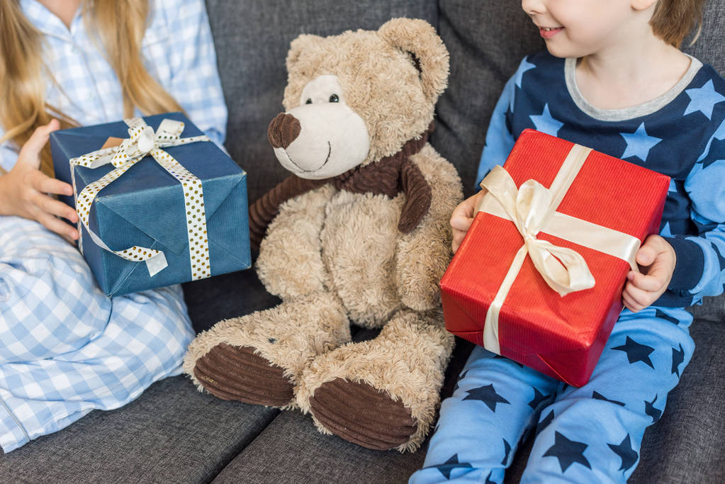 oříznuté snímek šťastné sourozenci v pyžamu drží vánoční dárky - Fotografie, Obrázek