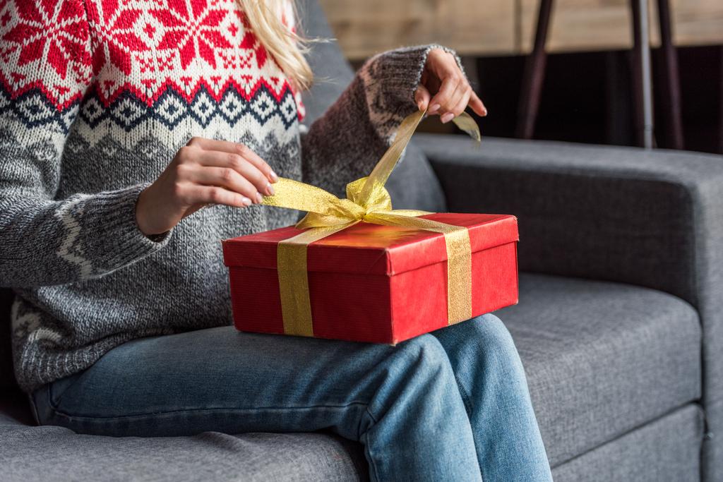 levágott lövés a fiatal nő karácsonyi ajándék otthon megnyitása téli pulóver - Fotó, kép