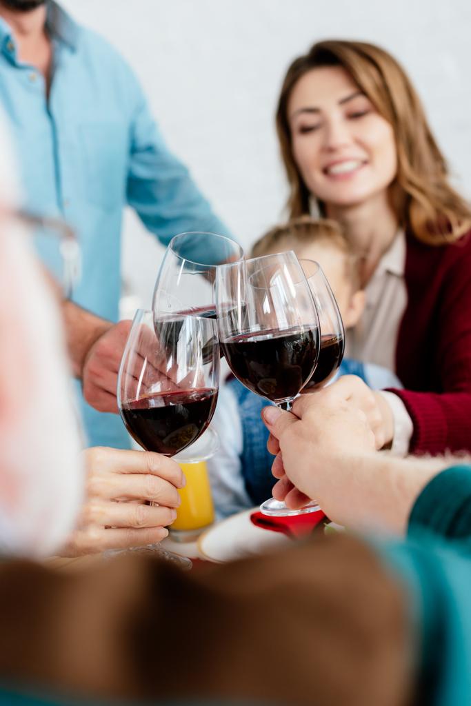 частичный взгляд на большую семью звон с бокалами вина и празднование Дня благодарения за обслуживаемым столом
  - Фото, изображение