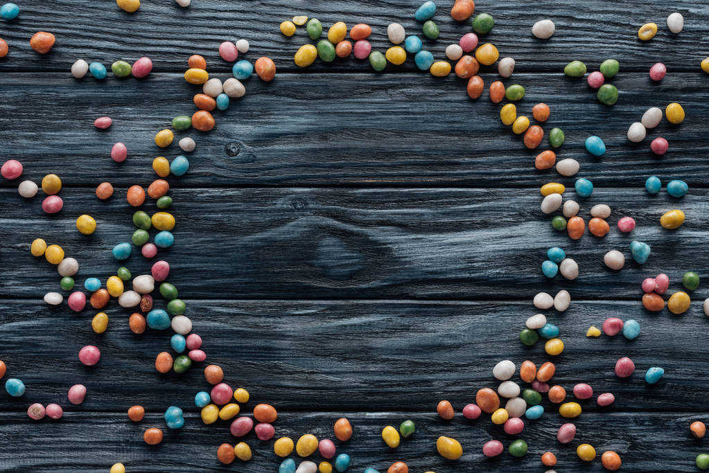 коло з різнокольорових смачних цукерок на дерев'яному фоні
   - Фото, зображення