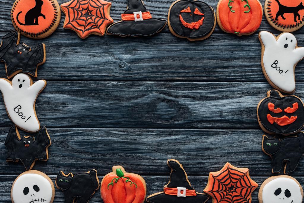 frame made of spooky halloween homemade cookies on black wooden background - Photo, Image