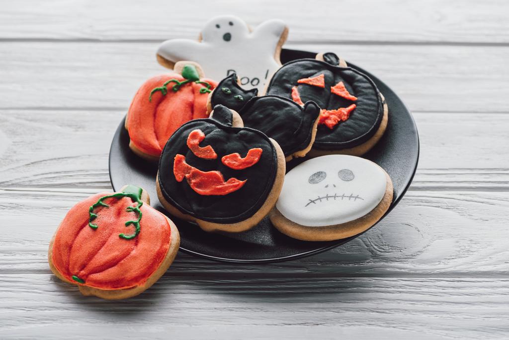 close up view of plate with spooky halloween cookies on wooden table  - Photo, Image