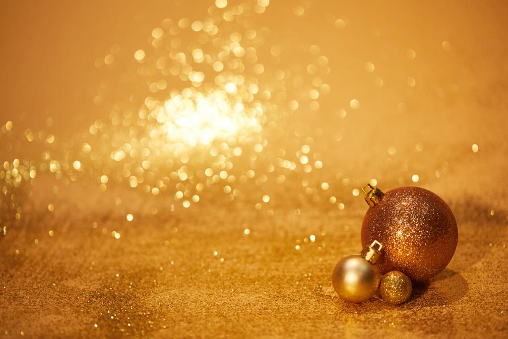 Χρυσή λαμπερά Χριστούγεννα παιχνίδια για διακόσμηση σε επιτραπέζια - Φωτογραφία, εικόνα