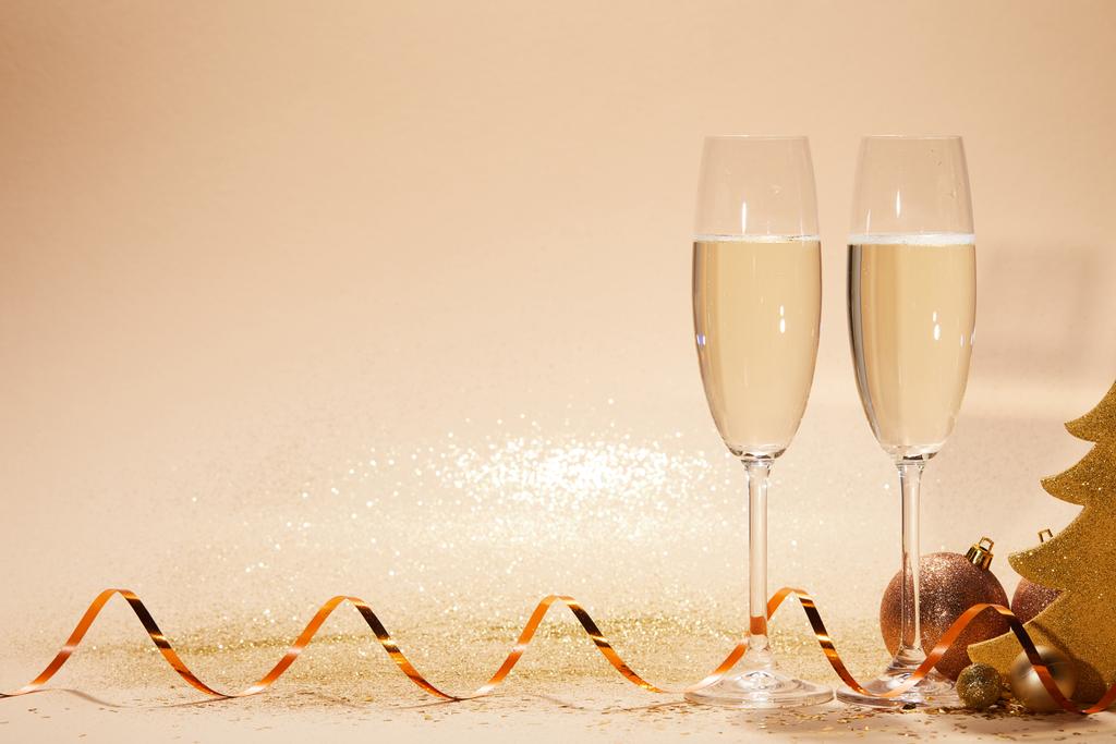 christmas toys, decorative star and two glasses of champagne with glitter on tabletop - Photo, Image