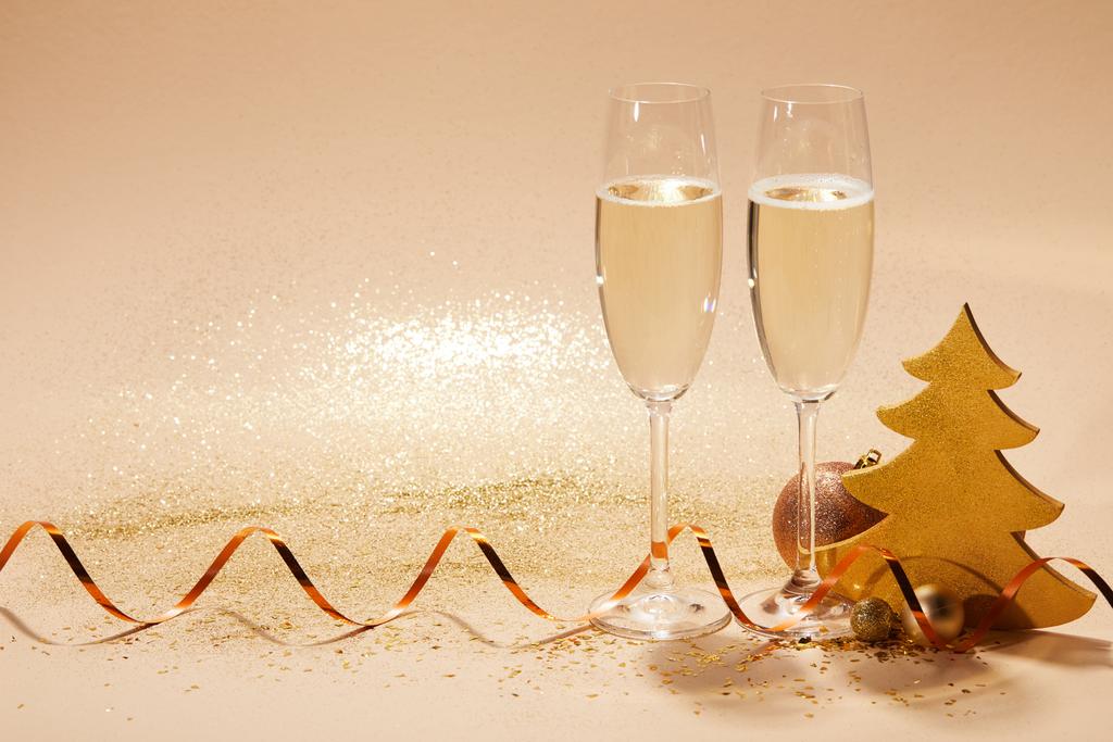 deux verres de champagne avec ruban ondulé et paillettes sur la table, concept de Noël
 - Photo, image