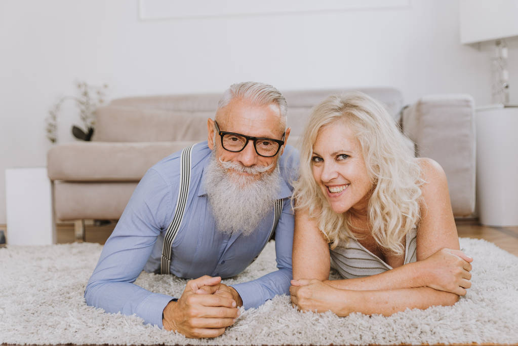 Seniorenpaar in den 60er Jahren hat Spaß zu Hause - fröhliches Ehepaarporträt, Konzepte über Alter und Beziehung - Foto, Bild