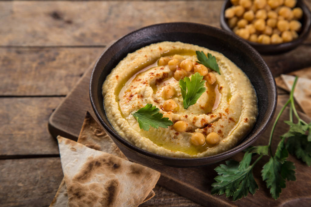 healthy homemade chickpea hummus with olive oil and smoked paprika, wooden background, selective focus - Photo, Image