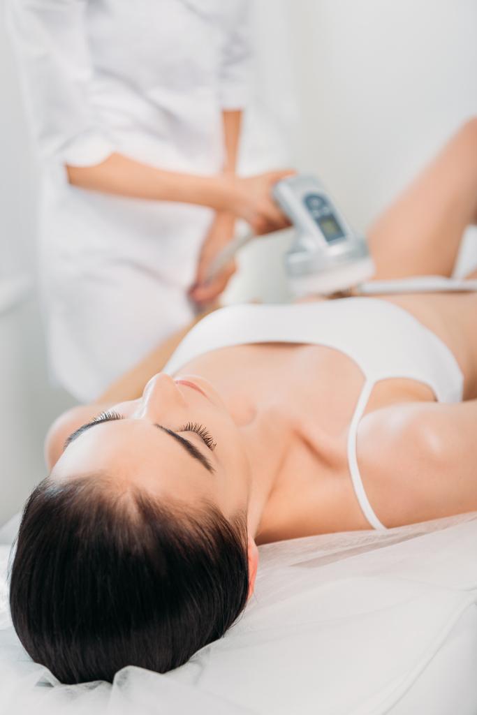attraktive Frau bekommt elektrische Massage von Kosmetikerin im Wellness-Salon - Foto, Bild