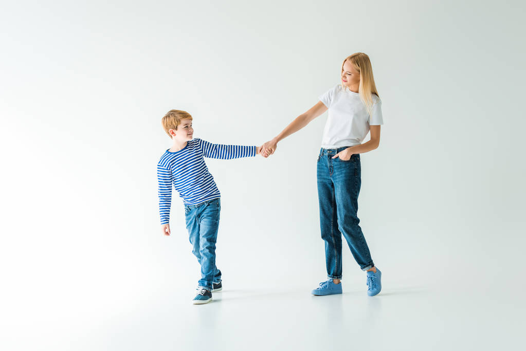μητέρα και γιος, κρατώντας τα χέρια και το περπάτημα σε λευκό - Φωτογραφία, εικόνα