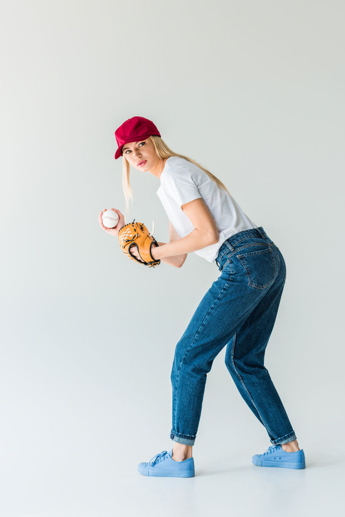 atractivo lanzador de béisbol en gorra roja con guante de béisbol y bola aislada en blanco
 - Foto, imagen