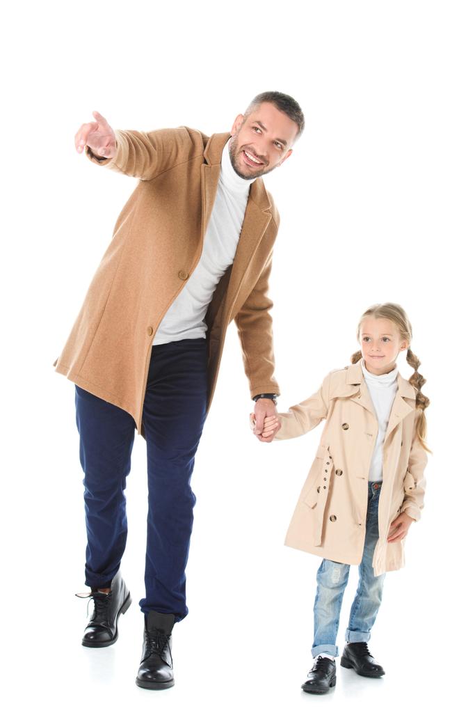schöner Vater zeigt seiner entzückenden Tochter im Herbst-Outfit etwas, isoliert auf weiß - Foto, Bild