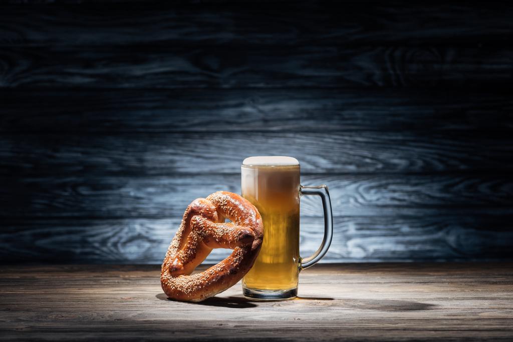 vaso de cerveza fresca y sabroso pretzel en la mesa de madera, concepto oktoberfest
 - Foto, Imagen