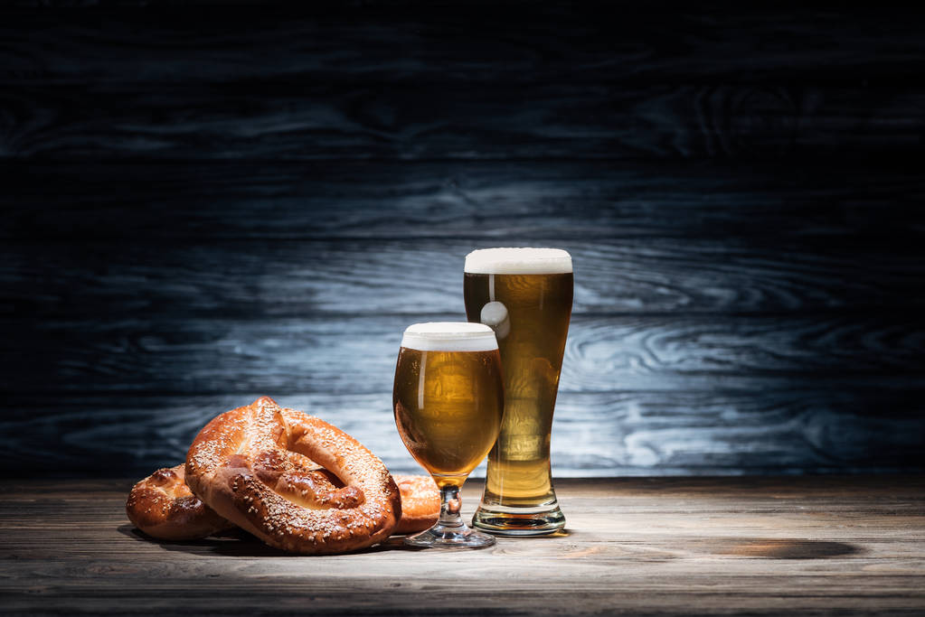 two glasses of tasty beer and yummy pretzels on wooden table, oktoberfest concept - Photo, Image