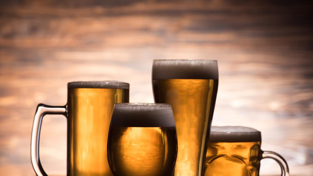 four glasses of golden fresh beer on wooden background, oktoberfest concept - Photo, Image
