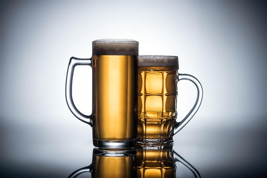 beer in glasses on reflecting surface, oktoberfest concept - Photo, Image