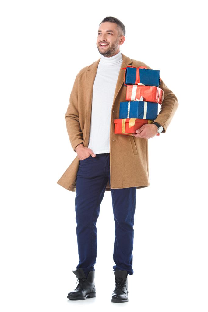 Красивый мужчина в бежевом осеннем пальто держит подарки, изолированные на белом
 - Фото, изображение