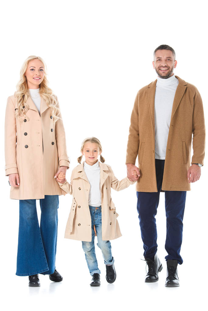 famiglia che si tiene per mano con la figlia e posa in cappotti autunno beige, isolato su bianco
 - Foto, immagini