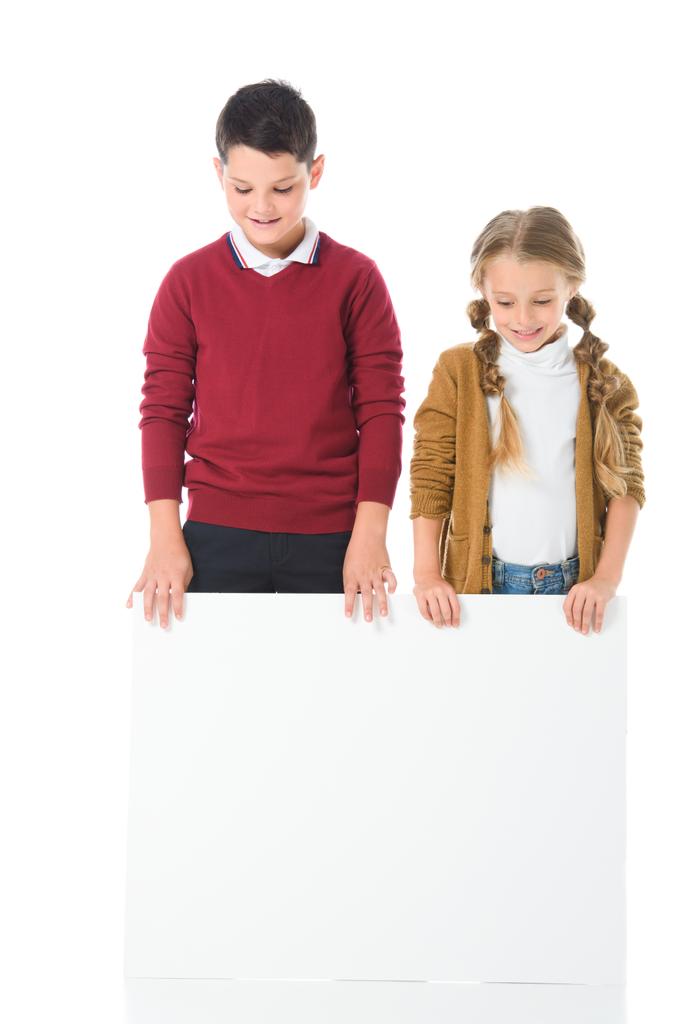 hermano y hermana de pie con la tabla vacía, aislado en blanco
 - Foto, Imagen