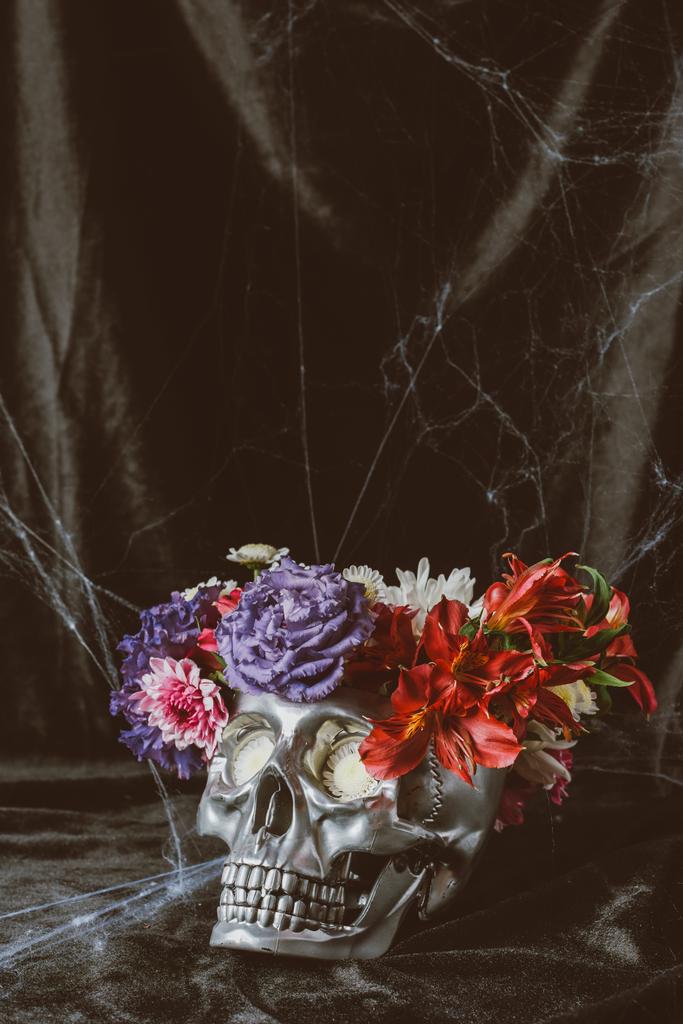 silver skull with flowers on black cloth with spider web for halloween - Photo, Image