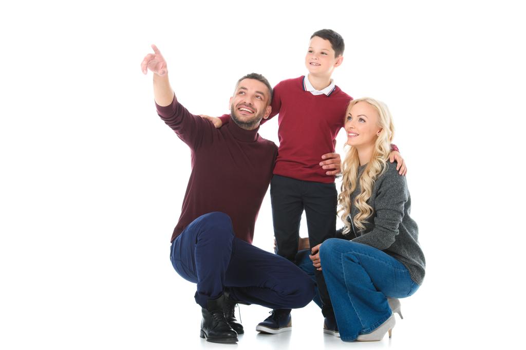 família feliz com filho em roupa de outono, homem mostrando algo isolado no branco
 - Foto, Imagem