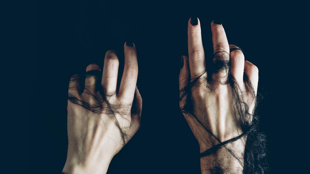 close up of female hands in black spider web isolated on black - Photo, Image