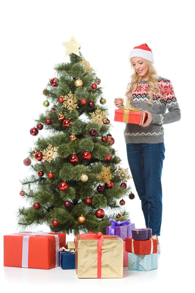 όμορφη γυναίκα ευτυχισμένη βάζοντας δώρα κάτω από το χριστουγεννιάτικο δέντρο, που απομονώνονται σε λευκό - Φωτογραφία, εικόνα