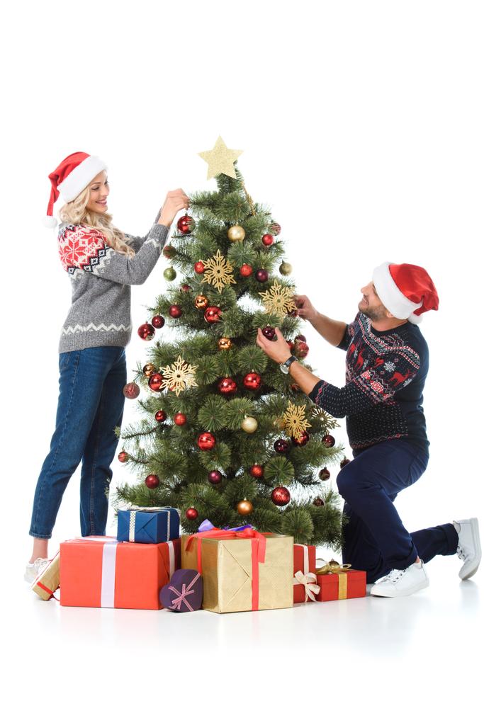 feliz casal em santa chapéus de decoração árvore de natal com presentes, isolado em branco
 - Foto, Imagem