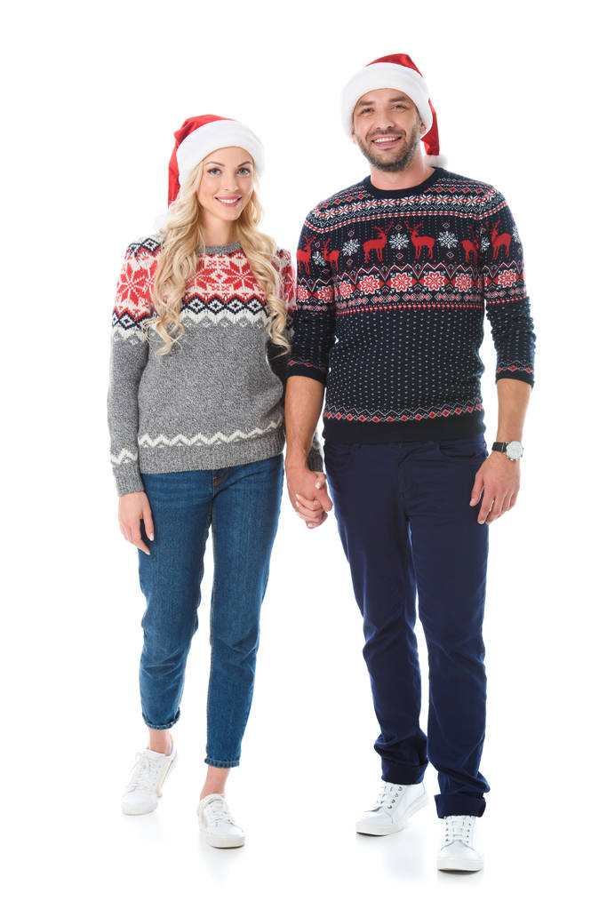 pareja en suéteres de Navidad y sombreros de santa cogidos de la mano, aislados en blanco
 - Foto, imagen
