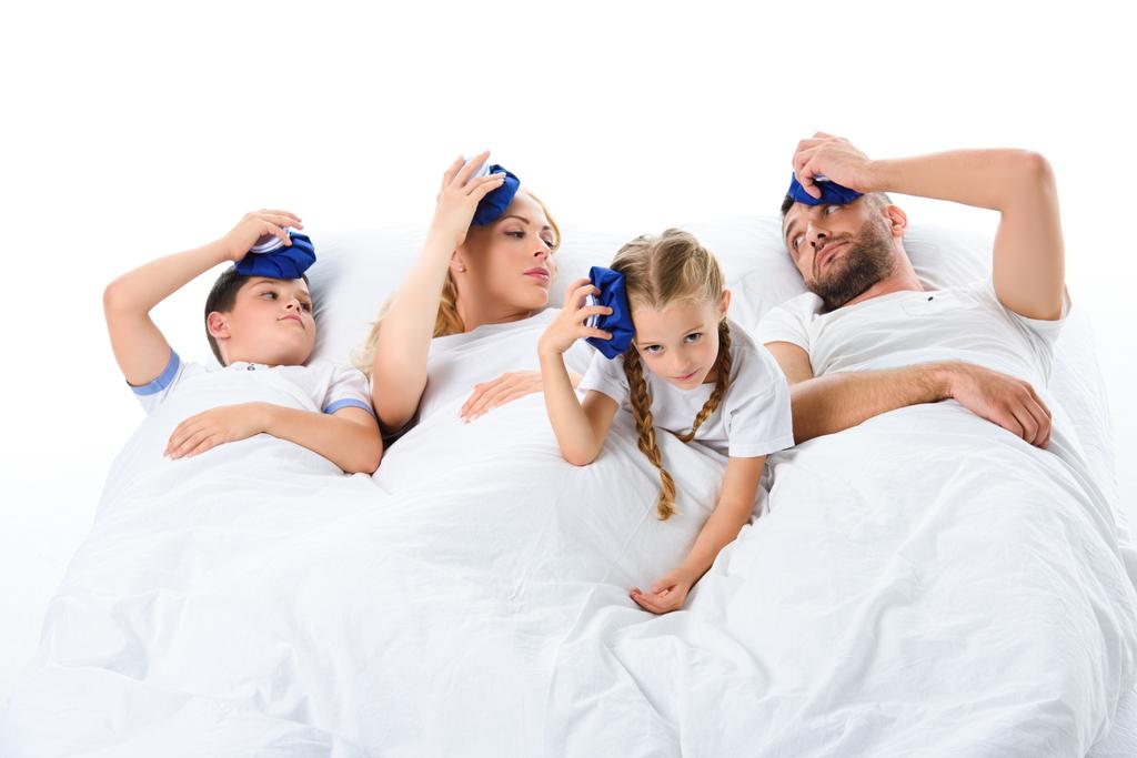 upset sick family with temperature holding ice packs on heads, isolated on white - Photo, Image