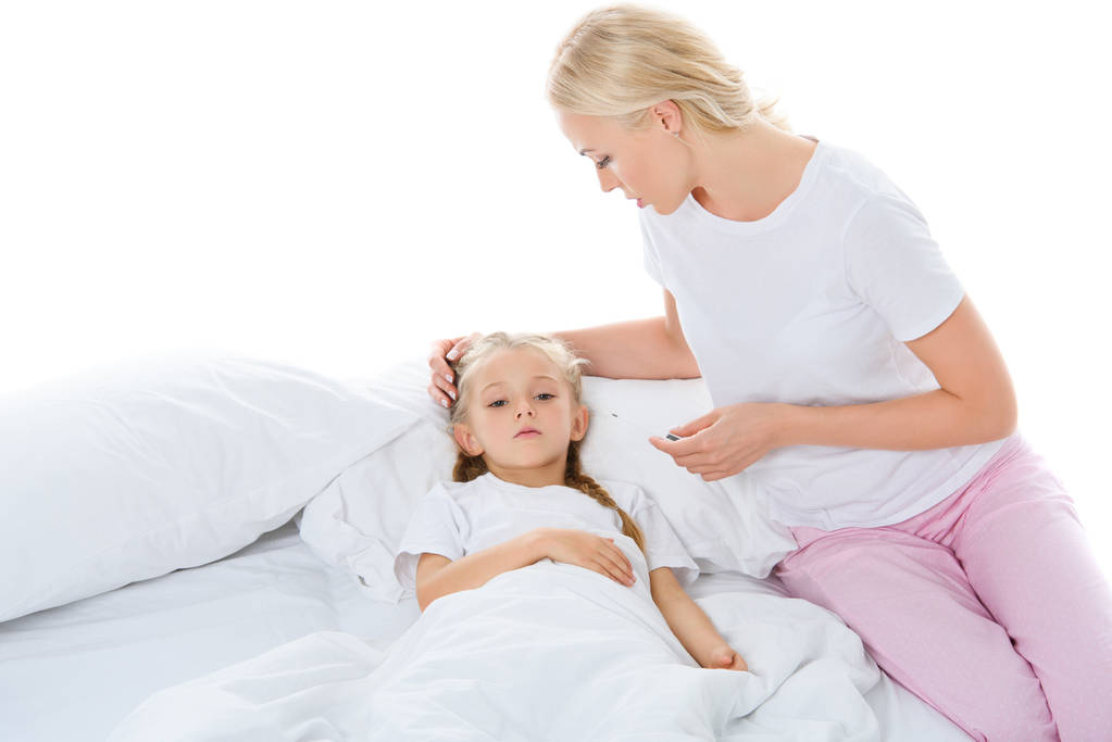 matka z Termometr elektroniczny, patrząc na córkę chory w łóżku, na białym tle - Zdjęcie, obraz