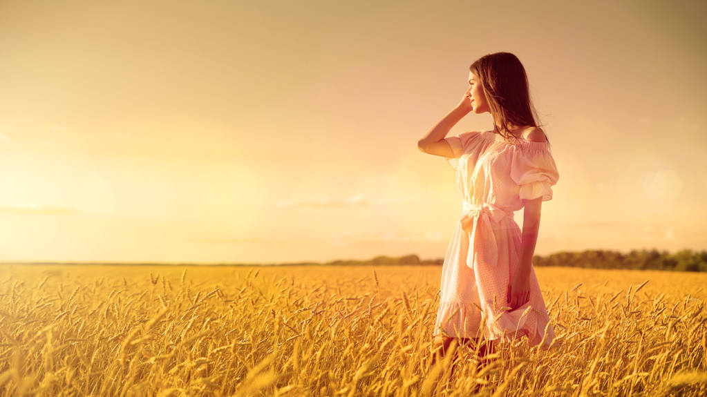 Nuori tyttö vehnäpellolla auringonlaskun aikaan
 - Valokuva, kuva
