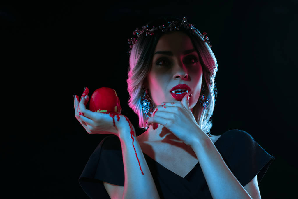 gothic woman with red bloody apple isolated on black - Photo, Image