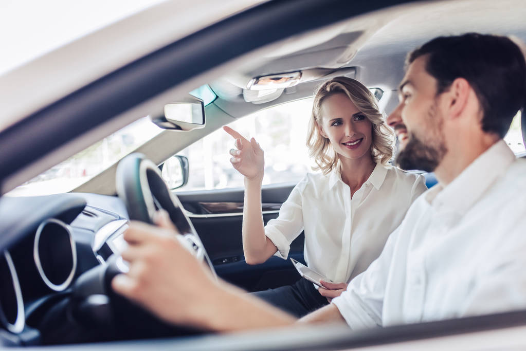 retrato de casal caucasiano sorridente falando enquanto dirige um carro
 - Foto, Imagem