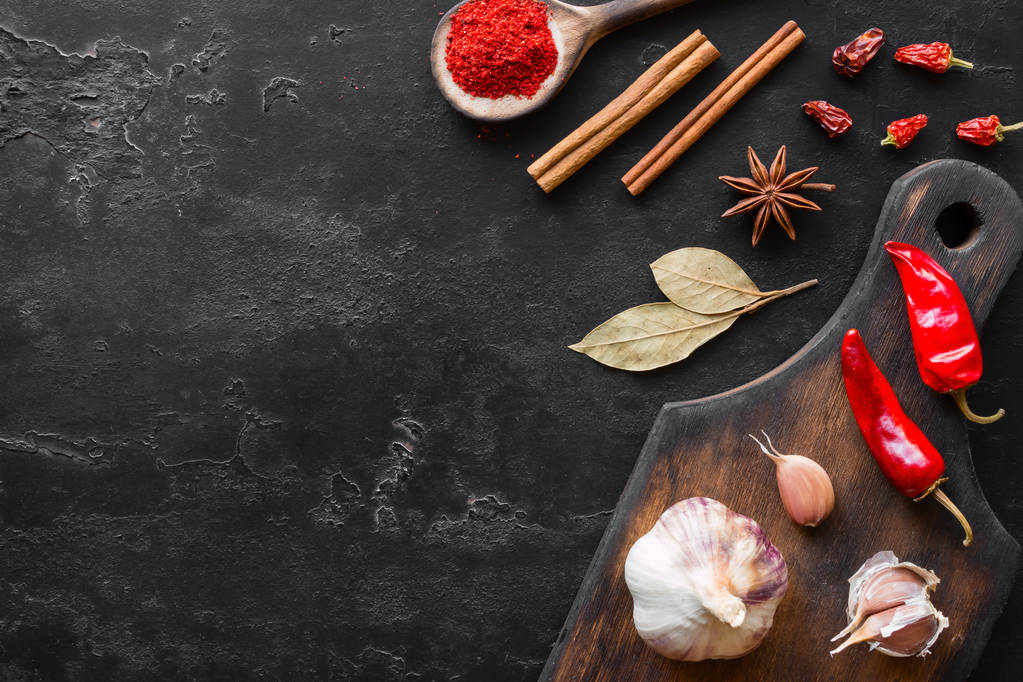 cutting board with spices and herbs on a black background and space for text - Photo, Image