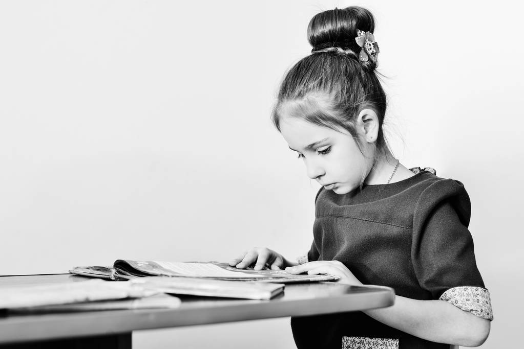 κορίτσι ανάγνωση του βιβλίου και να κάθεται στο τραπέζι - Φωτογραφία, εικόνα