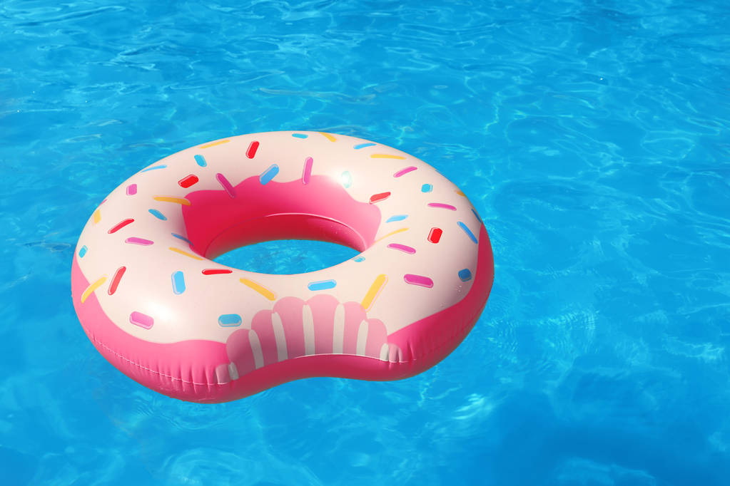 Anel inflável flutuando na piscina no dia ensolarado
 - Foto, Imagem