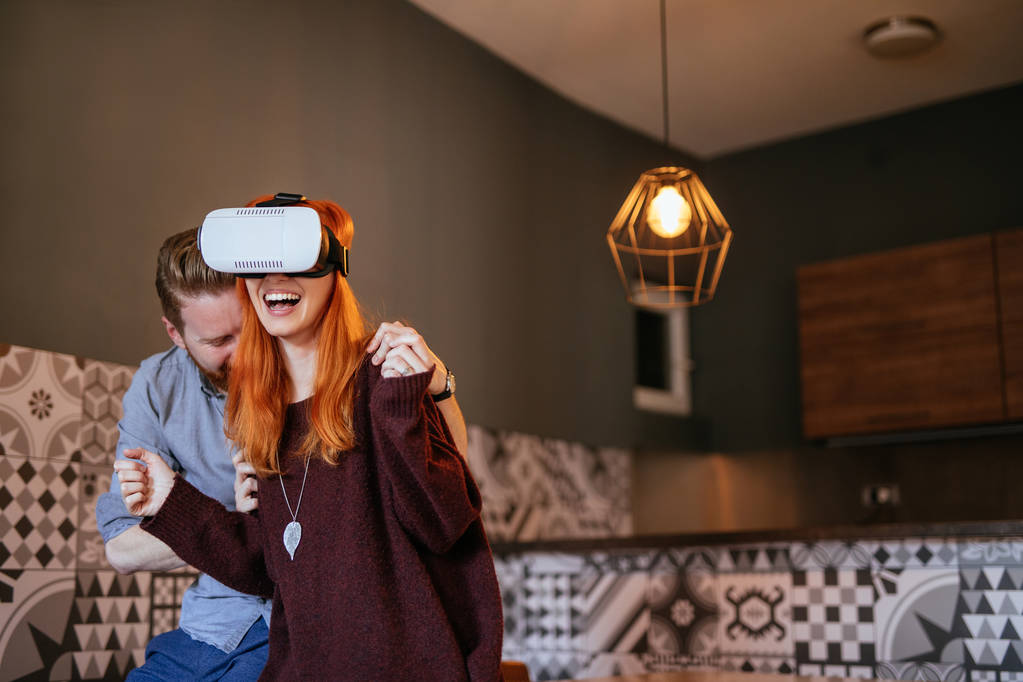 Photo of young cheerful couple bonding trough virtual reality. - Photo, Image