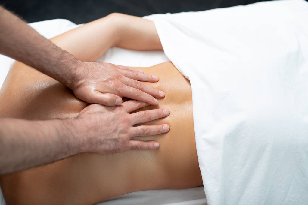 Massaggiatore professionista che fa massaggio terapeutico sulla schiena della signora
 - Foto, immagini