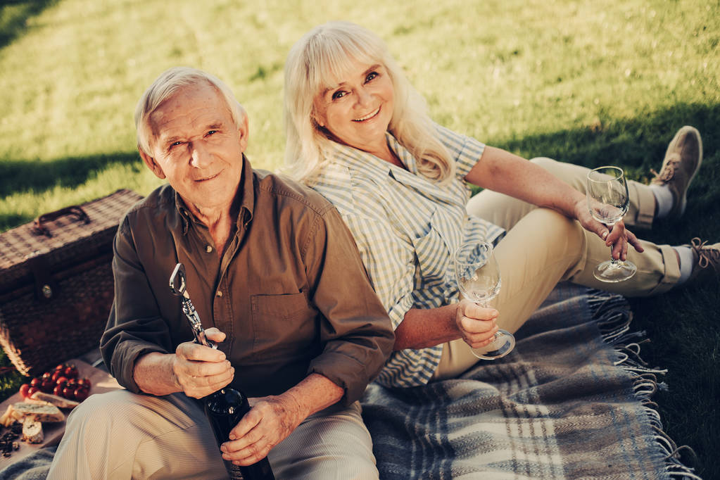 Cheerful smiling mature twosome having picnic outdoors - Photo, Image