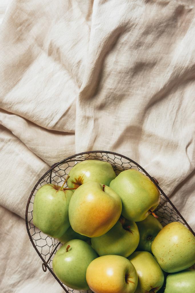 vue de dessus des pommes vertes dans le panier en métal sur toile de sac
 - Photo, image