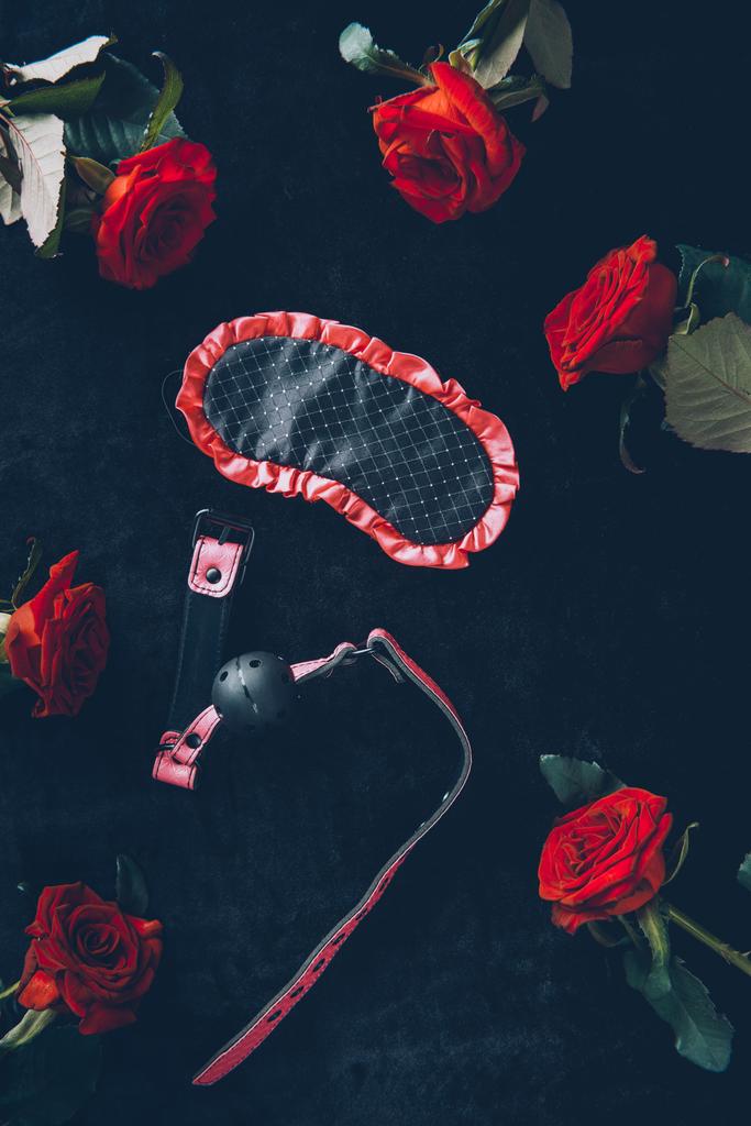vue du haut du masque pour les yeux, bâillon et roses rouges sur noir
 - Photo, image